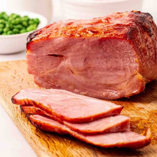 A cooked air fryer gammon joint on its side, sliced up a little, on a board and ready to eat.