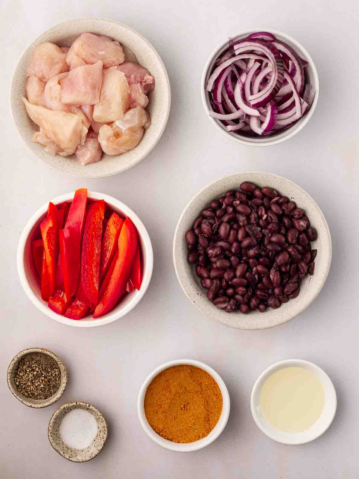 The ingredients for Air Fryer Mexican Chicken in bowls laid out on a counter.
