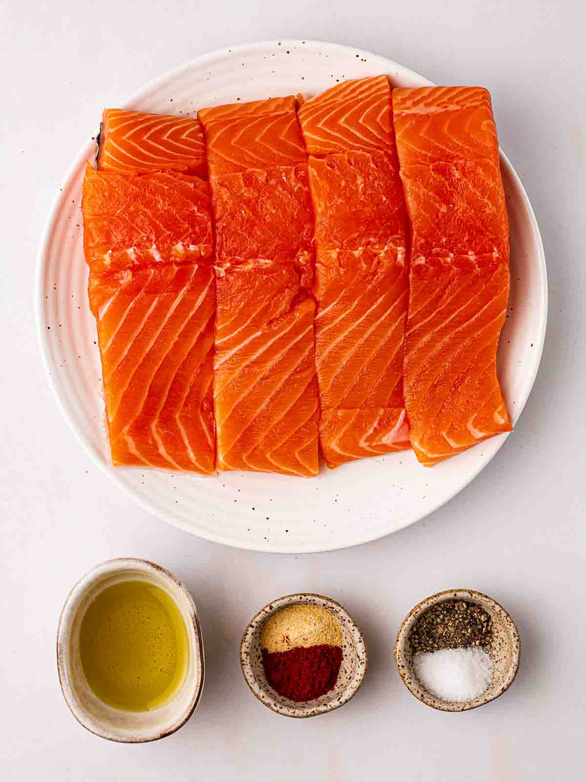 The raw ingredients for making air fryer salmon laid out on a counter top.