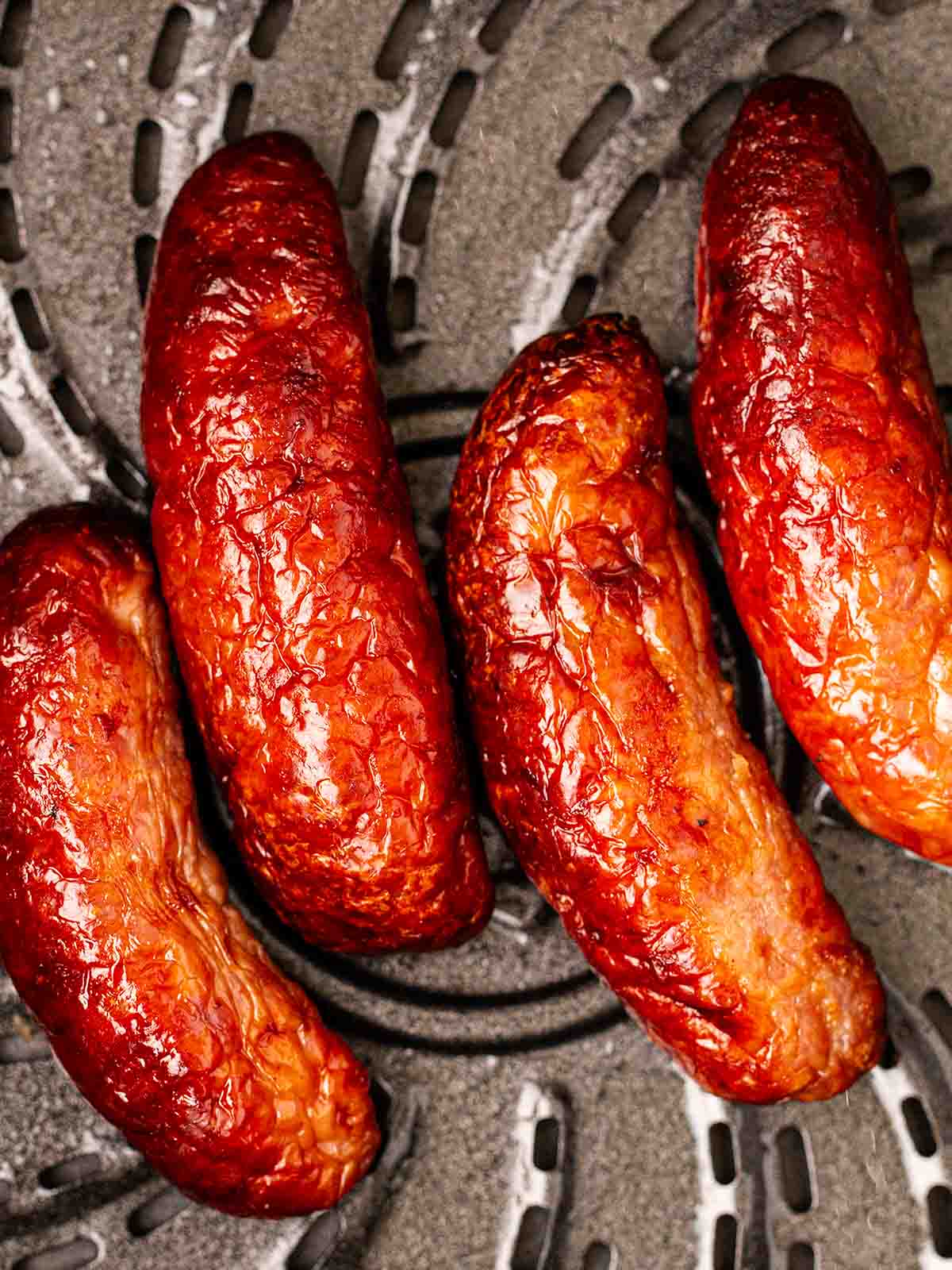 Cooked sausages in an air fryer pan.