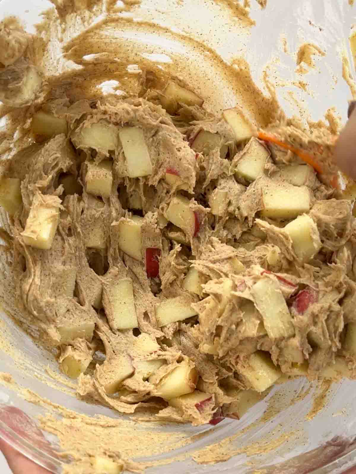 Chunks of apple with cake mixture in a glass bowl.