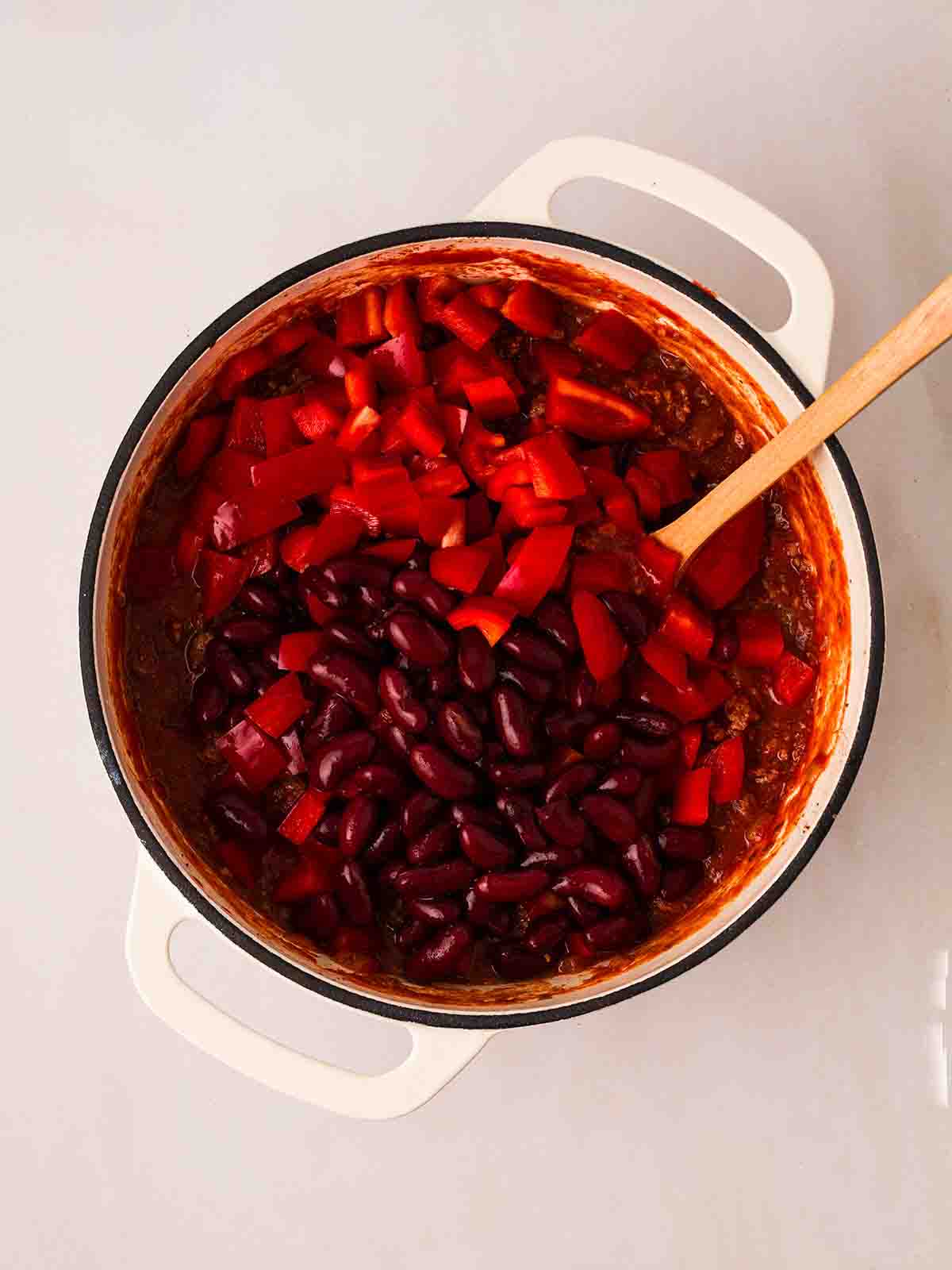 A pan filled with beef mince, red peppers and kidney beans for step 2 in the recipe for Beef Enchiladas.