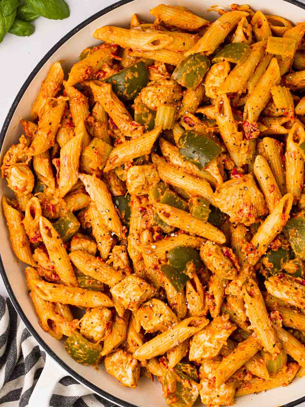 A large bowl of cooked Cajun Chicken Pasta with green peppers.