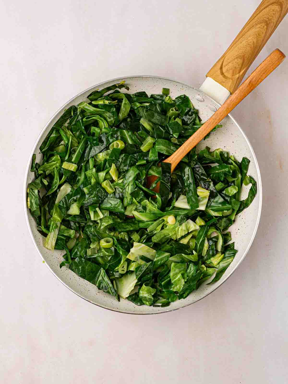 A pan filled with green cabbage for step 2 in the recipe for Colcannon.