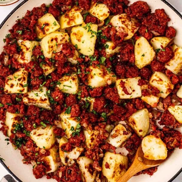 A close up of a plate of Corned Beef Hash, with cubed potatoes and tinned corned beef hash.
