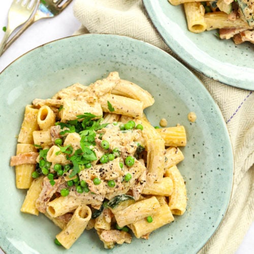 Cream cheese pasta recipe with bacon and vegetables, on a plate.