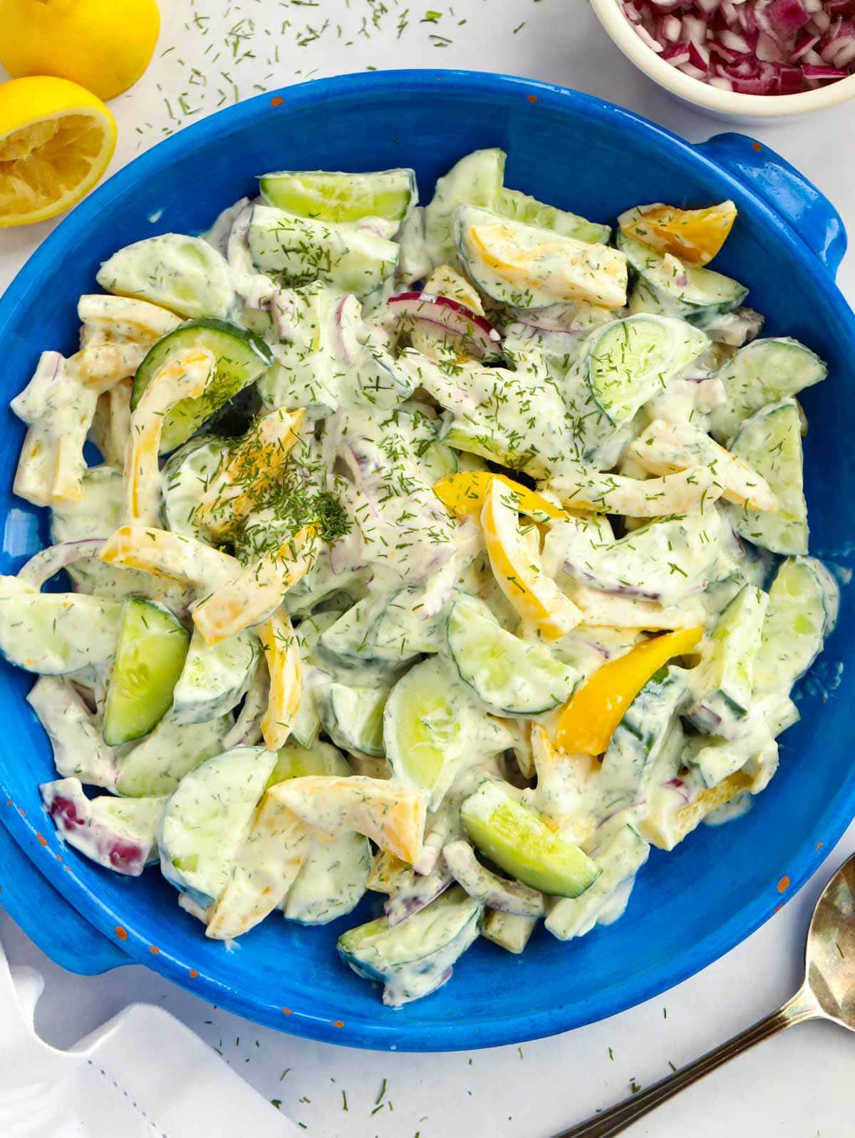 Easy Cucumber Salad Recipe with healthy yoghurt dressing in a blue bowl.
