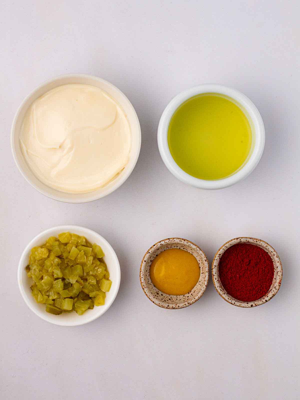 Small bowls of Big Mac Sauce ingredients on a white counter top.