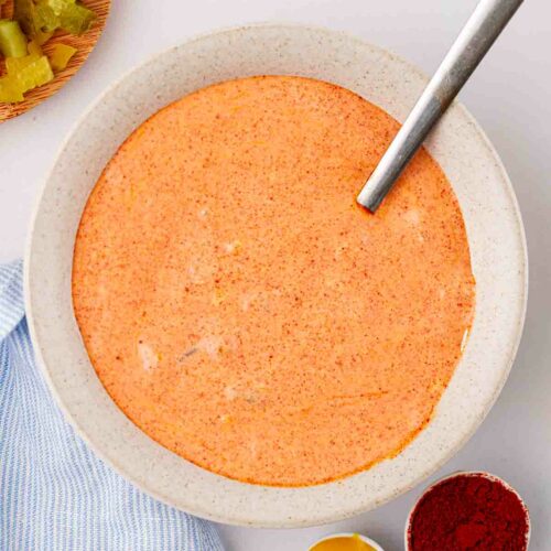 An orange Big Mac sauce in a bowl with spices and ingredients to the side.