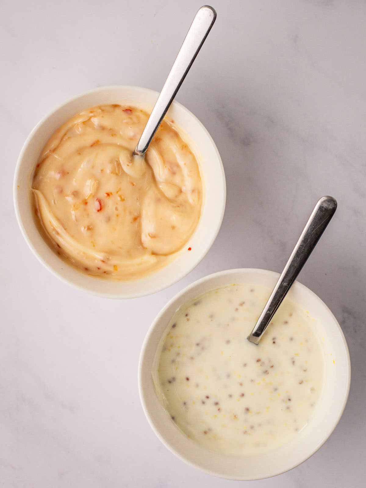 The dips in a bowl with spoons to accompany chicken nuggets.