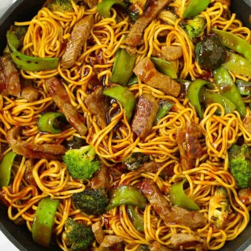 A pan with cooked beef and vegetables mixed together.