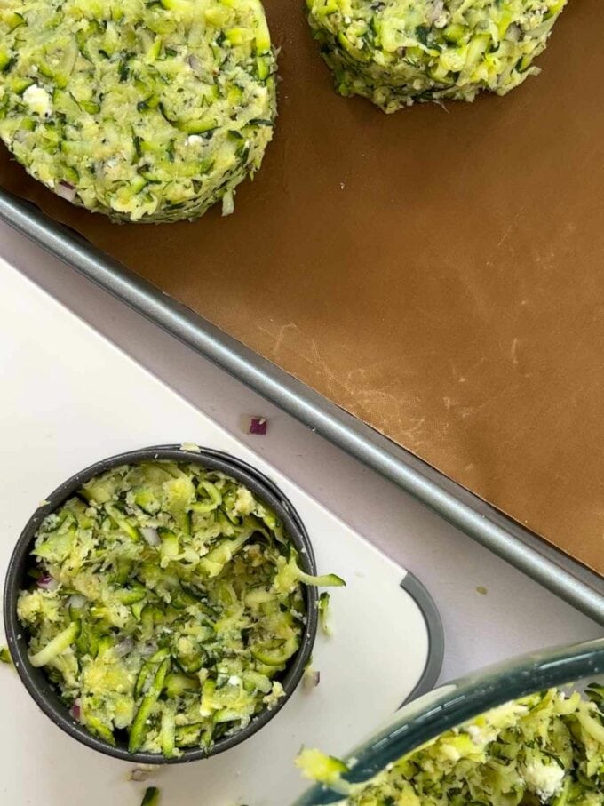 How to make Courgette Fritters. Step 3. Shape the patties into eight rounds on a baking tray.