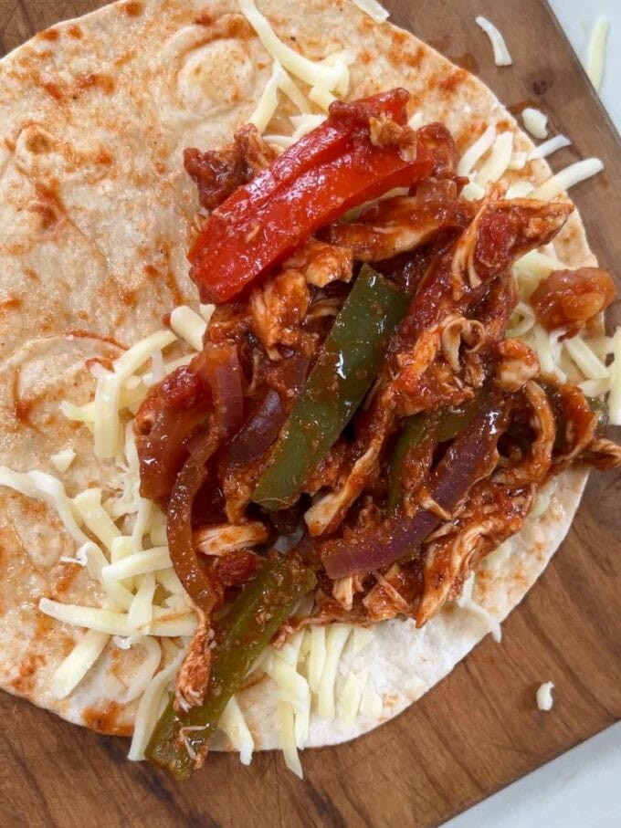 Step 3 in the recipe for Chicken Tacos. Add chicken mixture and cheese to one side of a tortilla.