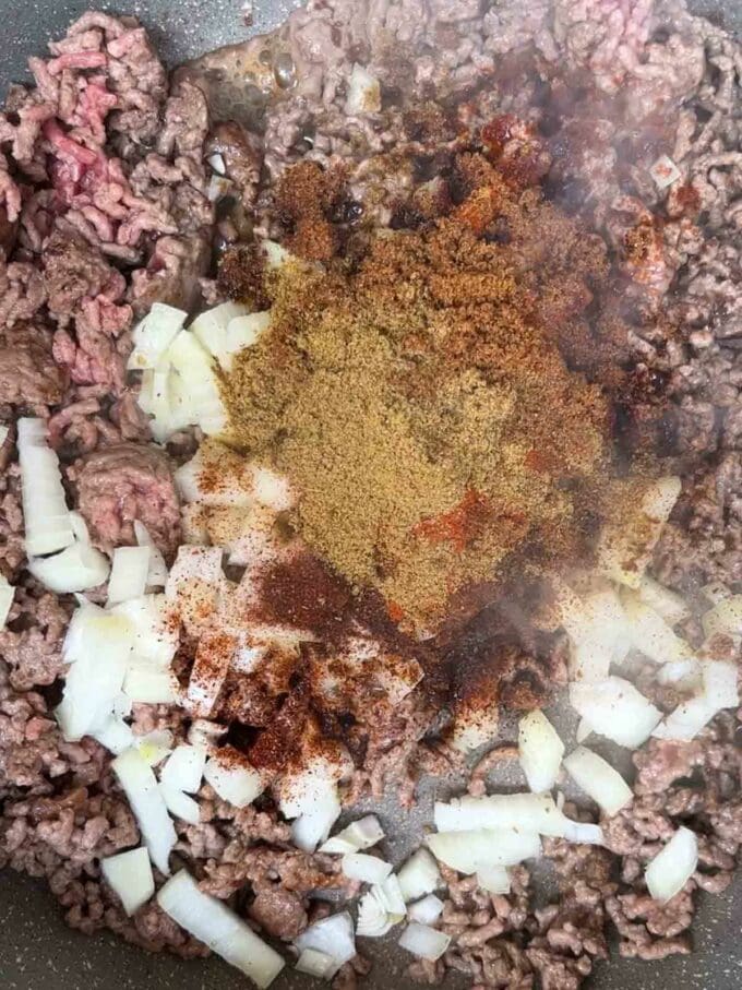 How to make Beef Burritos. Step 1. Fry beef and onion with spices in a pan.
