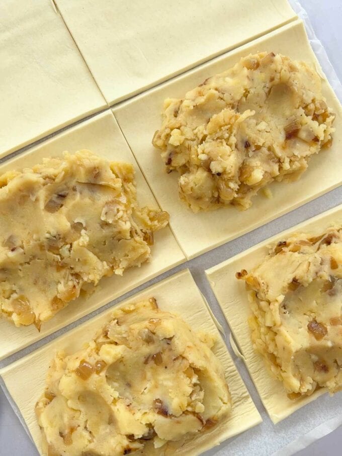 How to make Cheese and Onion bakes. Step 2. Cut the pastry into 8 rectangles. Add the filling.