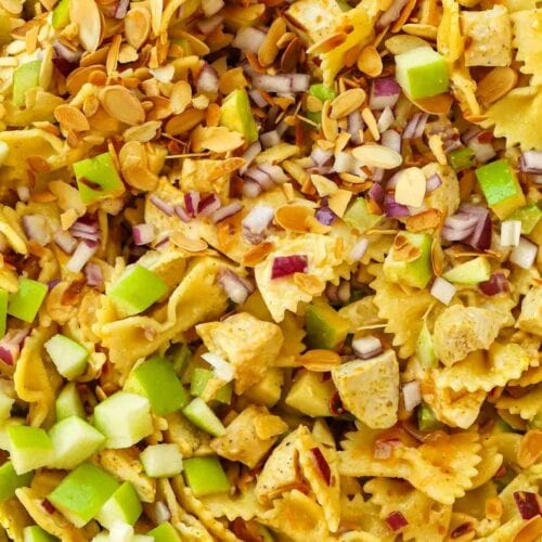 A combination of ingredients that make up a Chicken Pasta Salad, all cooked and mixed together, ready to eat.