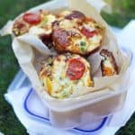 Mini Crustless Quiches in a box on grass, ready for a picnic.