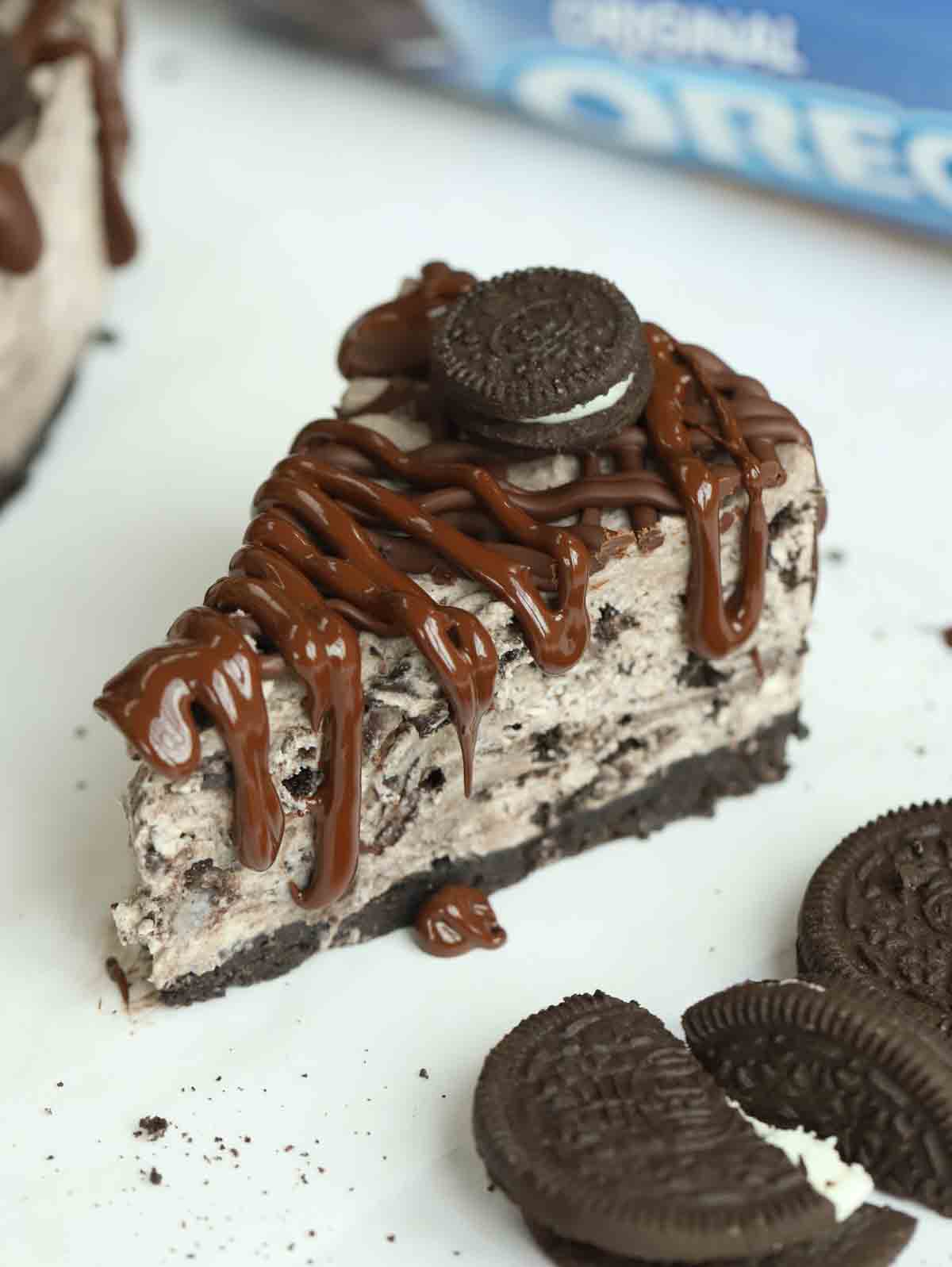 A slice of Oreo Cheesecake from a side angle on a white counter.