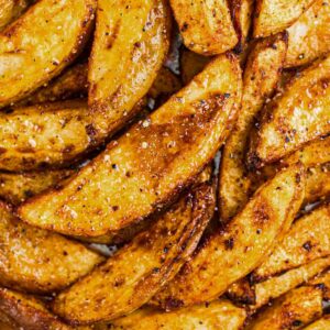 A close up of lots of crispy, golden homemade potato wedges.