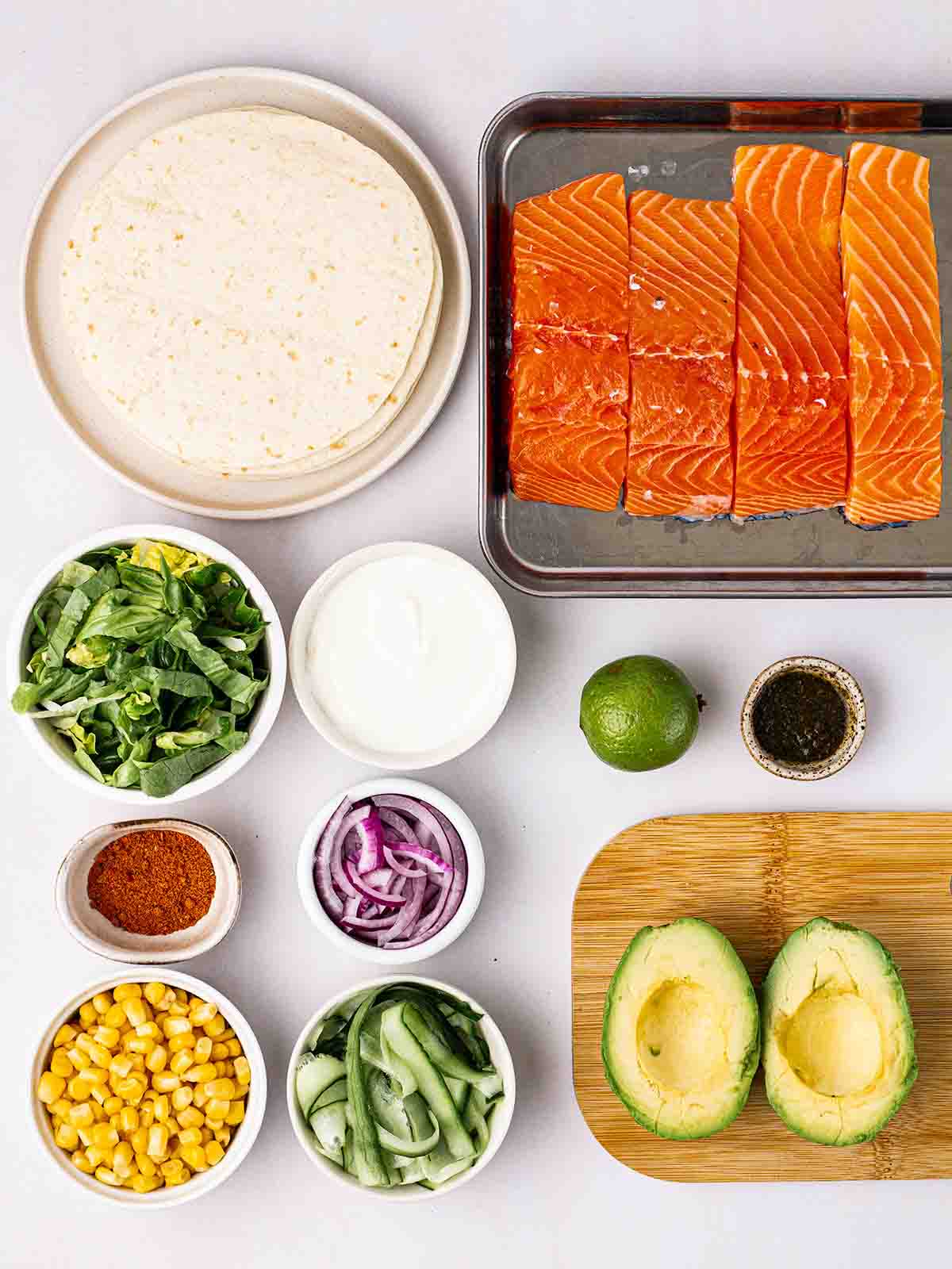The ingredients for making Salmon Tacos laid out on a white counter.