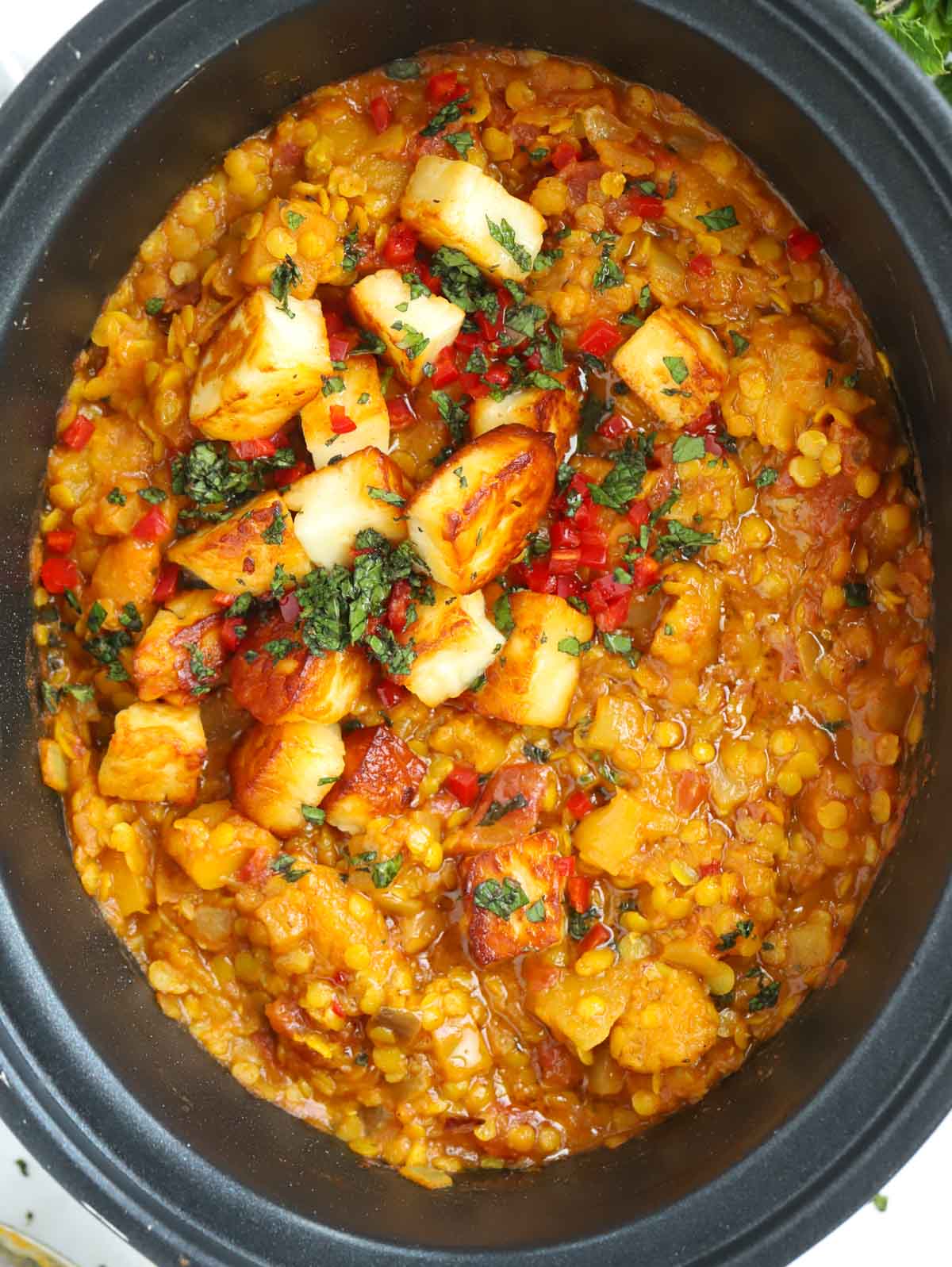 A finished Slow Cooker Dahl recipe topped with paneer and coriander.