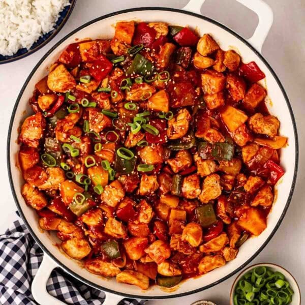 A pan of Sweet and Sour chicken, ready to serve onto plates.