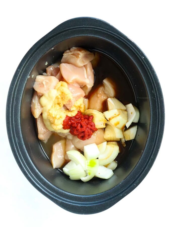 Raw ingredients in a slow cooker pan for the recipe sweet and sour chicken.