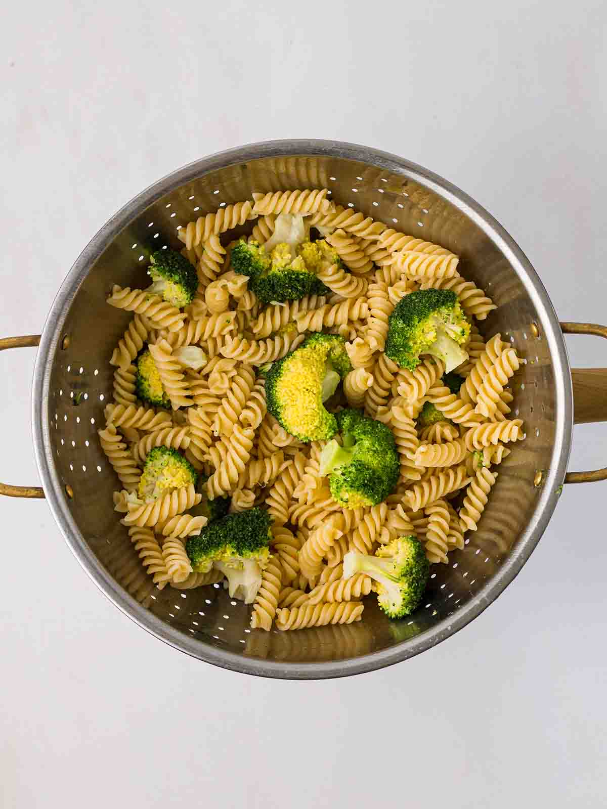 Cooked pasta and broccoli in a colander for the recipe Tuna Pasta Bake.