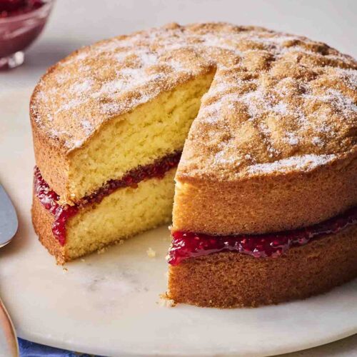 A Classic Victoria Sponge Cake, already with a piece missing.
