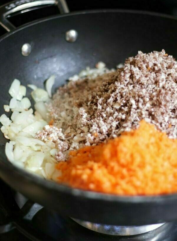 Very finely chopped mushrooms and carrots and onions in a le creuset wok frying pan for making Pork Yuk Sung recipe.